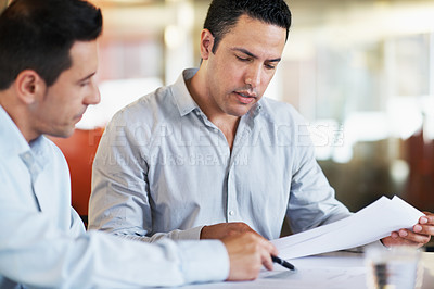 Buy stock photo Two business partners in the office discussing company numbers