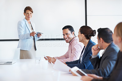 Buy stock photo Portrait of a young smiling businessman sitting beside his coworkers during a presentation