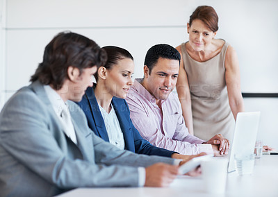 Buy stock photo A group of business people during a seminar with a female manager leaning on the board room table