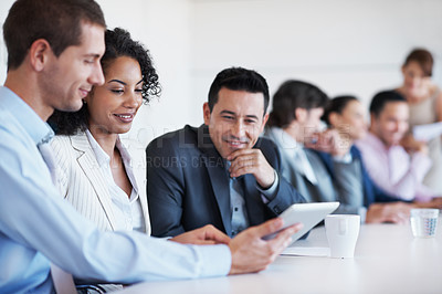 Buy stock photo Shot of a group of businesspeople looking at a digital tablet