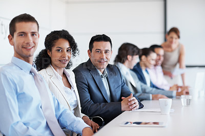 Buy stock photo A group portrait of business colleagues during staff training with coworkers blurred in the background