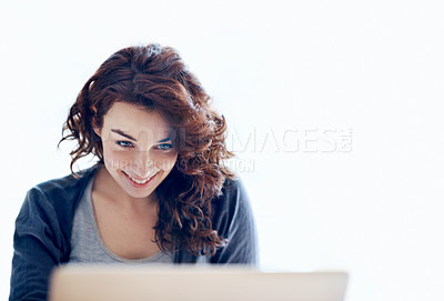 Buy stock photo A pretty young woman browsing the internet on her laptop at home - copyspace
