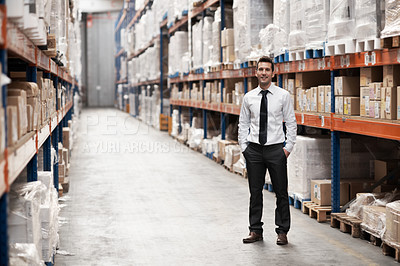 Buy stock photo Handsome warehouse manager standing in the warehouse surrounded by boxes