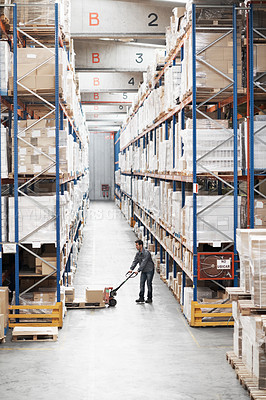 Buy stock photo A young man moving inventory in a storehouse using a pallet truck