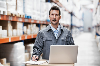 Buy stock photo Portrait of a young man working on his laptop while working in a warehouse