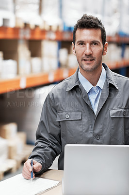 Buy stock photo Portrait of a young man using his laptop while working in a storehouse