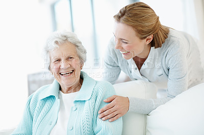 Buy stock photo Smile, comfort and old woman at house with daughter, love and connection for bonding together. Portrait, person and laugh in lounge with senior mother, compassion and elderly care for weekend break