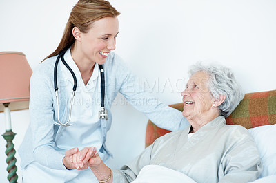 Buy stock photo Caregiver, holding hands and senior woman in bed for homecare, healthcare and support with smile. Help, happy and medical service with nurse and elderly patient in retirement at  nursing home