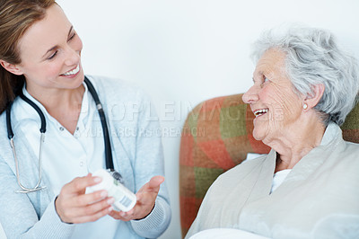 Buy stock photo Caregiver, healthcare and elderly woman with pills for healing, laugh or wellness prescription. Patient, medical nurse and giving medicine bottle for senior care, funny and help with dose at home