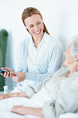 Buy stock photo Smile, caregiver and old woman in home with glucometer, testing sugar and analysis for blood levels. Happy, nurse and senior person at house with machine, diabetes assessment and medical treatment