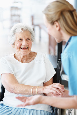 Buy stock photo Caregiver, laugh and holding hands with old woman on wheelchair, help and connection for healthcare. Trust, nurse and senior person with disability, medical support and funny joke at retirement home