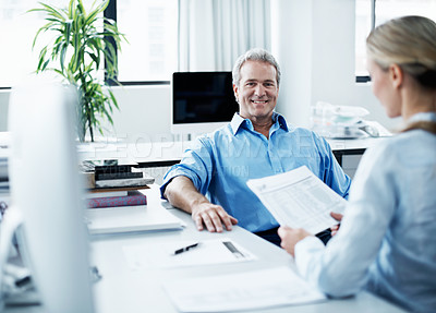 Buy stock photo Coworkers discussing work matters while seated at a desk together