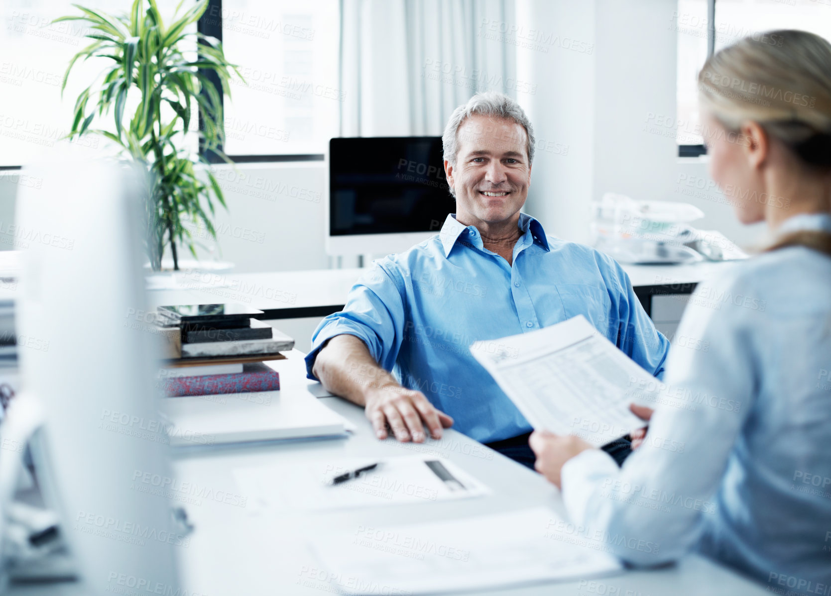 Buy stock photo Coworkers discussing work matters while seated at a desk together