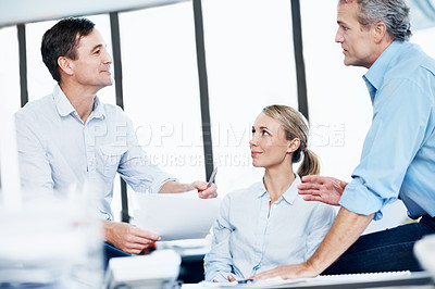 Buy stock photo Three colleagues looking over some documents in the office