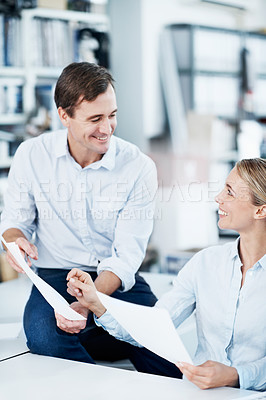 Buy stock photo Two coworkers looking over some paperwork in the office