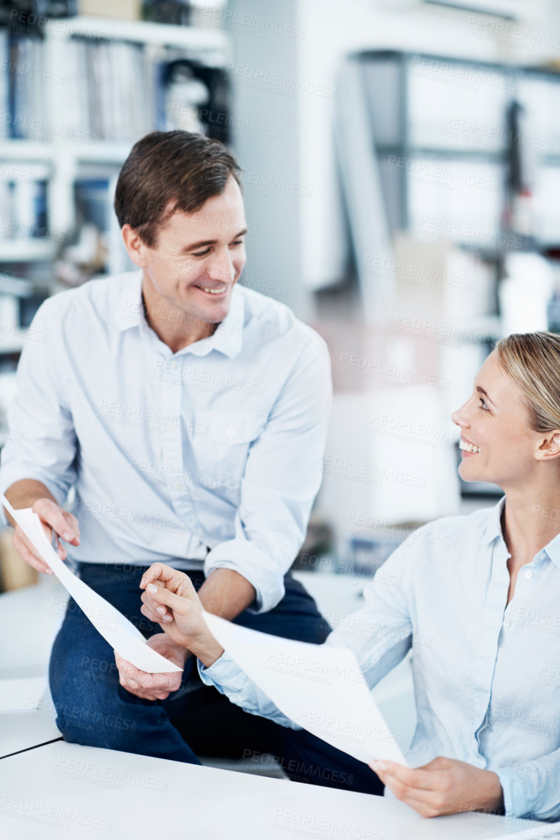 Buy stock photo Two coworkers looking over some paperwork in the office