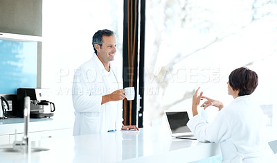 Buy stock photo Couple, coffee and relax with smile in kitchen, morning routine together and chat with laptop. Conversation, happy man listening and woman with drink at counter, tech and bonding on weekend at house