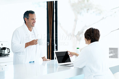 Buy stock photo Couple, coffee and laptop in kitchen with smile, relax and morning routine together with chat. Conversation, happy man and woman with drink at counter, technology and bonding on weekend at house