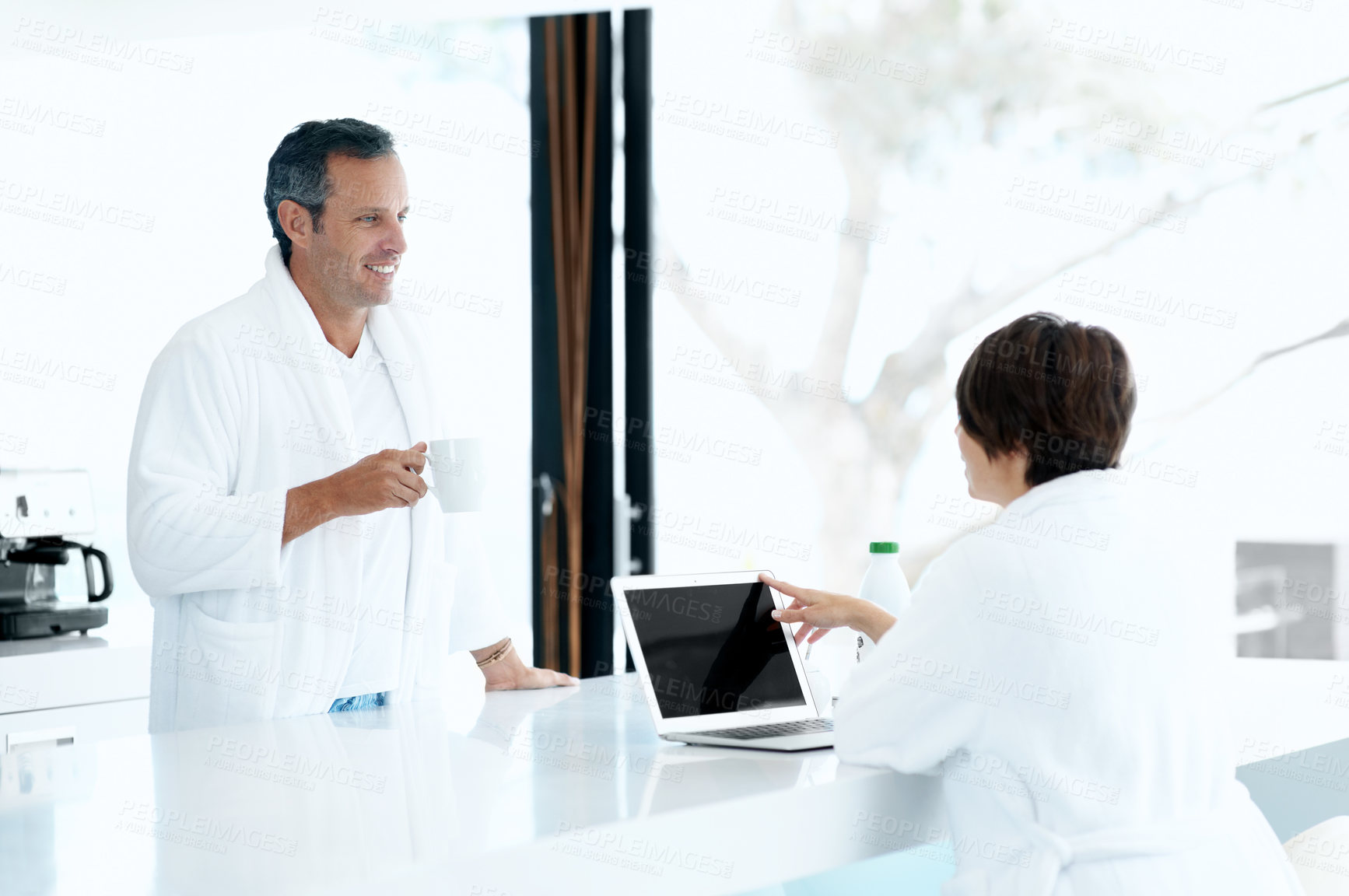 Buy stock photo Couple, coffee and laptop in kitchen with smile, relax and morning routine together with chat. Conversation, happy man and woman with drink at counter, technology and bonding on weekend at house