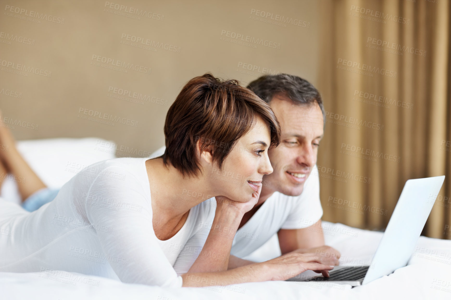 Buy stock photo Happy, laptop and couple relax in bedroom with love, care and bonding with comfort and web in home. Man, woman and technology on bed with internet connection, streaming online and movie subscription