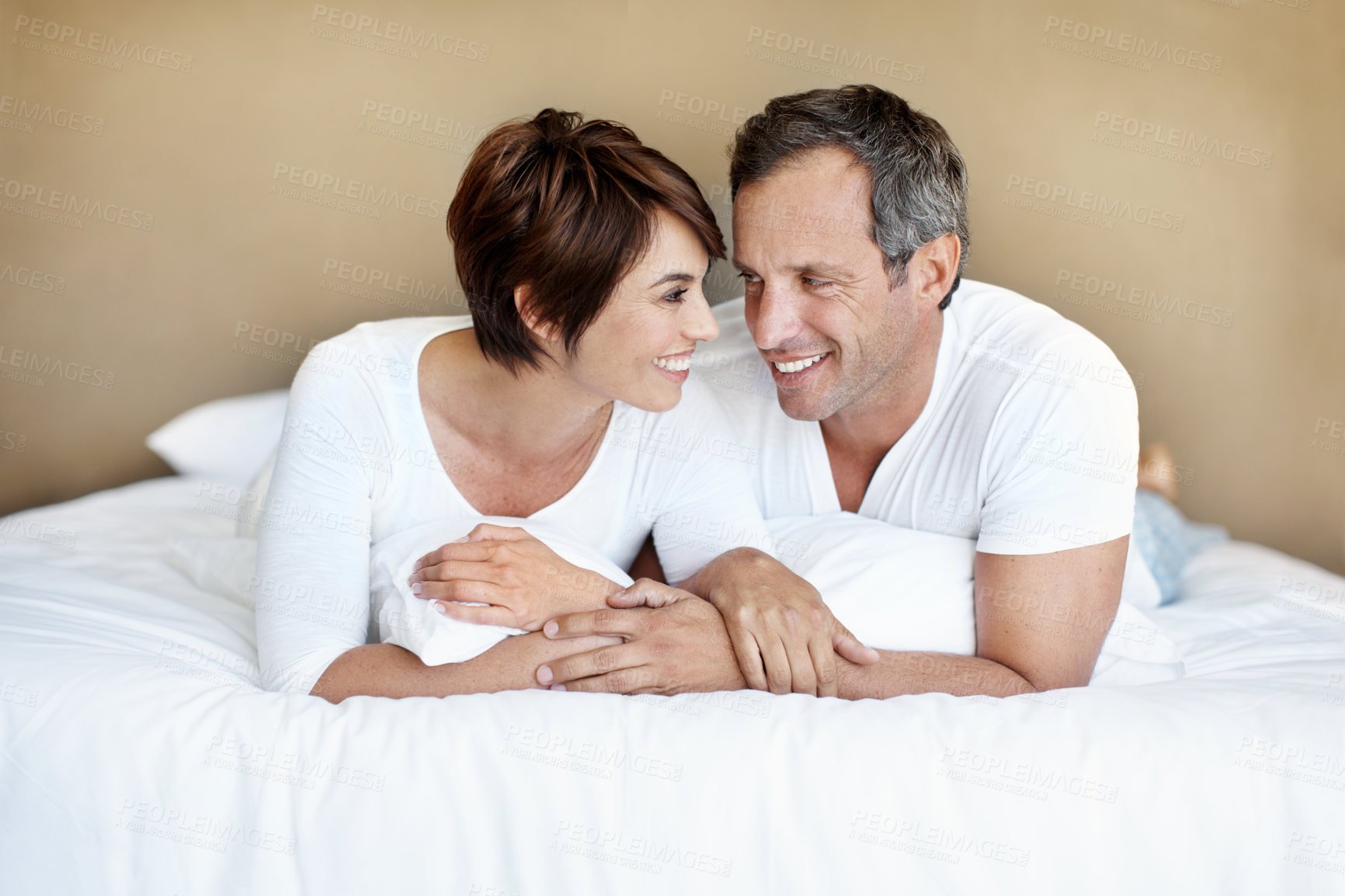 Buy stock photo Smile, morning and talk with couple in bedroom for romance, valentines day and marriage. Happy, getaway and care with mature man and woman in home or staycation for anniversary retreat and love