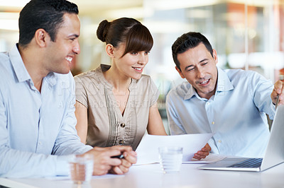Buy stock photo Shot of coworkers using a laptop at a table in an office