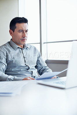 Buy stock photo Portrait of an executive working on a laptop while sitting at a table in an office