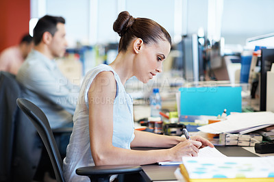 Buy stock photo Shot of a young professional at work at her desk in an office