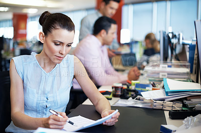 Buy stock photo Shot of a young professional at work at her desk in an office