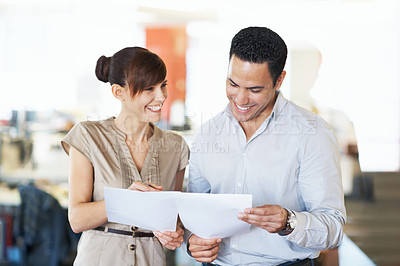 Buy stock photo Shot of two colleagues discussing paperwork in an office