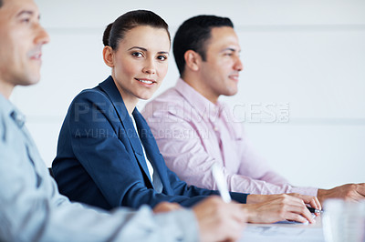Buy stock photo Portrait of a young businesswoman sitting at a conference table with her colleagues