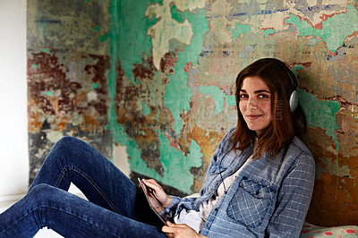 Buy stock photo Portrait of a young woman using a digital tablet and headphones indoors