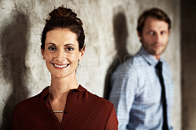 Buy stock photo Studio portrait of a smiling woman with her husband in the background