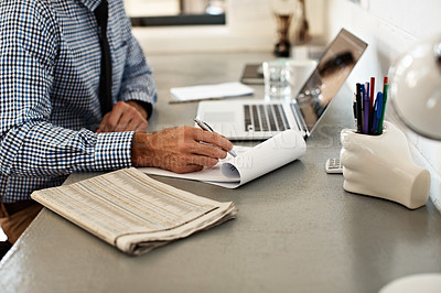 Buy stock photo Shot of a businessman going over paperwork while sitting at his desk in an office