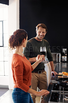 Buy stock photo Shot of a smiling mature couple drinking wine in their kitchen