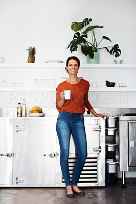 Buy stock photo Portrait of a woman standing in her kitchen drinking a coffee