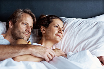 Buy stock photo Shot of a content mature couple lying in bed together