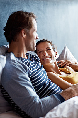 Buy stock photo Shot of a content mature couple lying in bed together