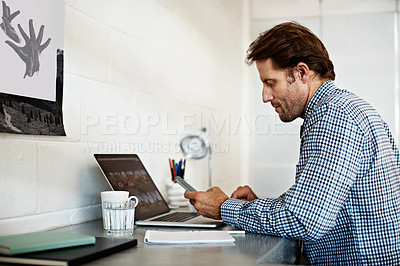Buy stock photo Shot of a businessman working on a laptop at his desk in an office