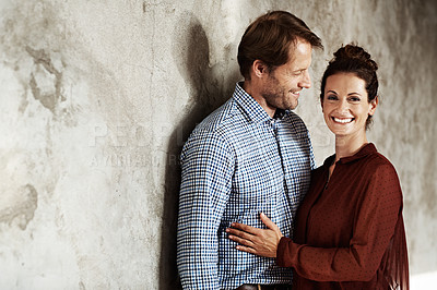 Buy stock photo Portrait of an affectionate couple leaning against a wall
