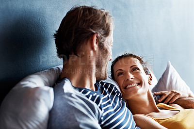 Buy stock photo Shot of an affectionate mature couple lying in bed together