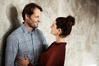 Buy stock photo Shot of an affectionate couple leaning against a wall