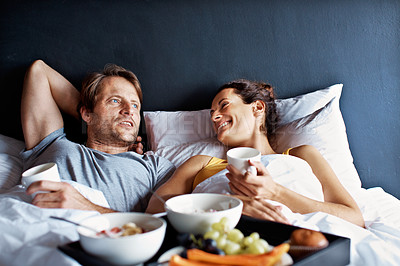 Buy stock photo Shot of a mature couple relaxing in bed with breakfast