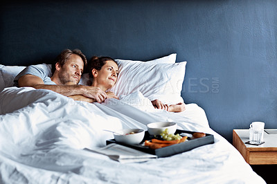 Buy stock photo Shot of a mature couple relaxing in bed with breakfast