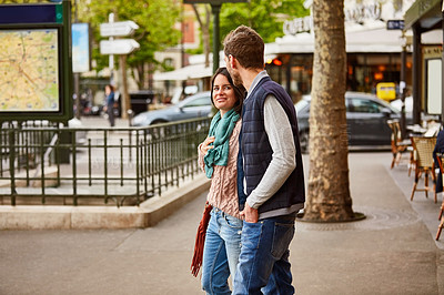 Buy stock photo Shot of a young couple enjoying the day together walking through the the city