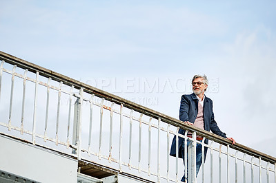 Buy stock photo Shot of a mature man admiring the view while leaning on the railing of a bridge