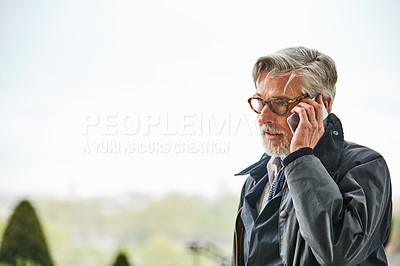 Buy stock photo Shot of a handsome mature man talking on a cellphone in the city