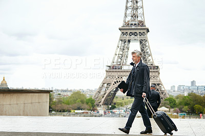 Buy stock photo Shot of a mature man walking with a suitcase in Paris with the Eiffel Tower in the background