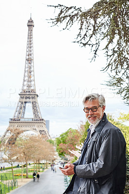 Buy stock photo Portrait of a handsome mature man using a cellphone in Paris with the Eiffel Tower in the background