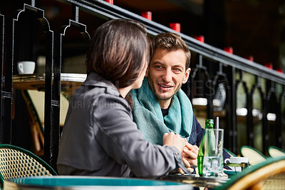 Buy stock photo Shot of a smiling couple sitting together at a table at a sidewalk cafe